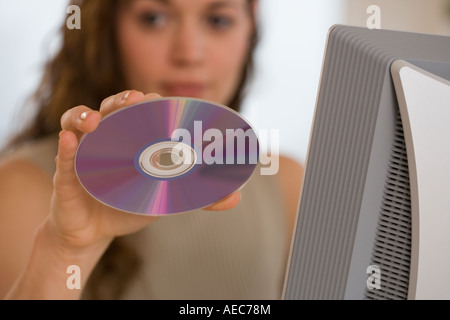 Hispanic woman holding up cd Stock Photo
