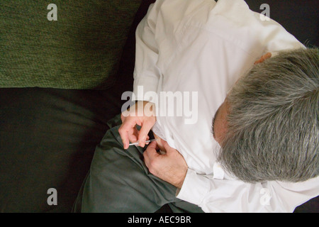 Man with diabetes self injecting insulin into his stomach area.. Stock Photo