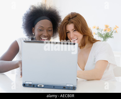 Two women looking at laptop and laughing Stock Photo