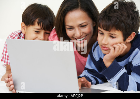 Indian mother and sons using laptop Stock Photo