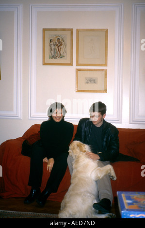 Young Couple Sitting on Sofa with Dog Stock Photo