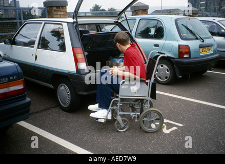 Young Man in Wheelchair Loading Boot of Car Stock Photo