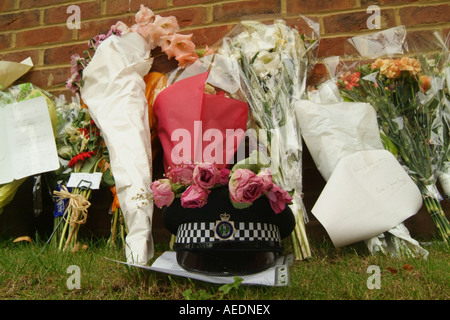 Floral tributes and a policeman's helmet left by the road where a policeman was killed in an accident. Stock Photo