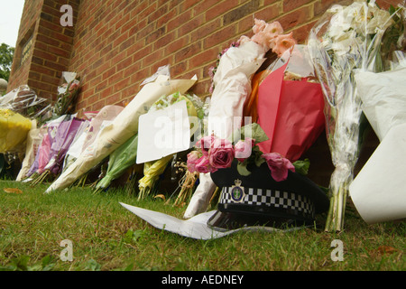 Floral tributes and a policeman's helmet left by the road where a policeman was killed in an accident. Stock Photo