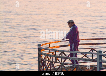 Mature man in jogging suit on a balcony looking out over the ocean Nerja Spain Stock Photo