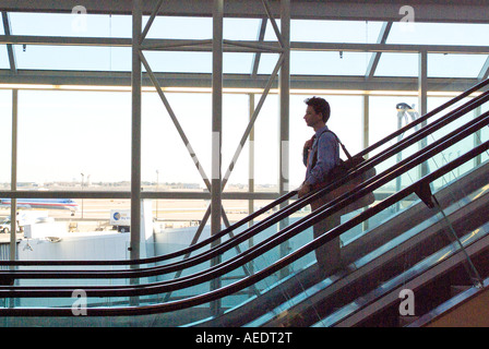 Person going down on escalator in airport terminal Stock Photo