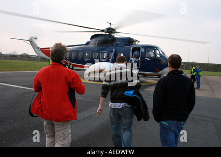 Tresco Helicopter, passengers embarking onto helicopter Stock Photo