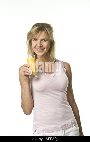 A woman smiling while holding a glass of juice. Stock Photo