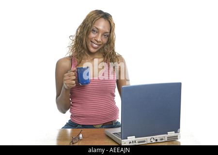 A young woman with a laptop computer and coffee mug. Stock Photo