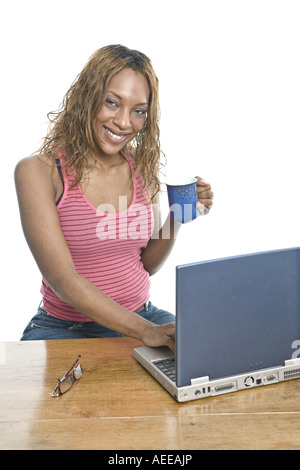 A young woman with a laptop computer and coffee mug. Stock Photo