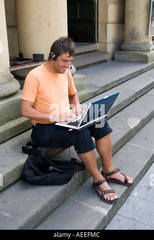 Man talking on Skype via a municipal wifi connection on a laptop computer, Spain Stock Photo