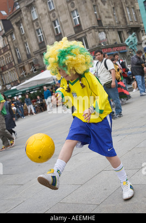 A young female fan of the Brazilian football team juggling with a ball in the city of Dortmund (Germany) Stock Photo