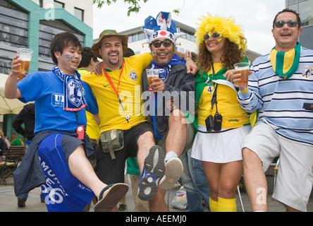 Football fans from Japan, Brazil and Argentina drinking beer and dancing together in good mood Stock Photo