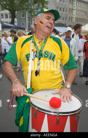 A Brazilian football fan walking through the city drumming in good mood before the world cup match Brazil vs. Ghana Stock Photo