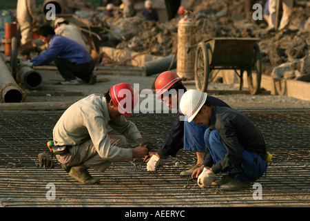 Shanghai China Construction workers completing road works on Xizang Zhonglu in the centre of Shanghai Stock Photo