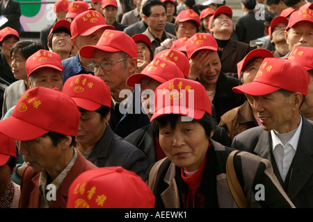 Shanghai, China :  Chinese tourists arrive at the Pearl Tower on Pudong in large tour groups, wearing identifying caps. Stock Photo