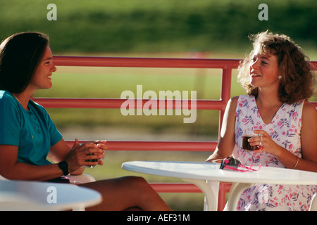 Friends conversing by table side view Stock Photo