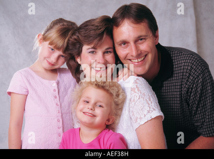 Family portrait ,Mom Dad two girls 2-3 4-5 year olds old Caucasian smiling heads together Stock Photo