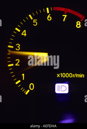 engine revolution counter dial on dashboard console of vehicle at night Stock Photo