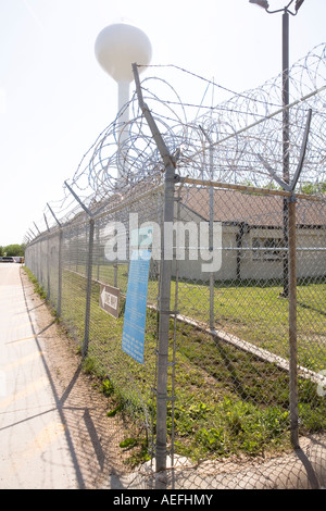 Perimeter fence with water tower in the background at the Nebraska Correctional Center for Women in York Nebraska USA Stock Photo
