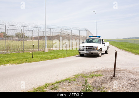 Patrol vehicle patrolling the outer perimeter fence at the Omaha Correctional Center Omaha Nebraska USA Stock Photo