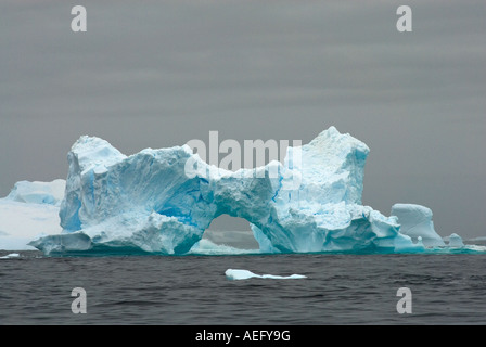 arched iceberg floating off the western Antarctic peninsula Antarctica Southern Ocean Stock Photo