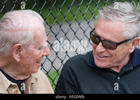 Two elderly men having a conversation smiling and sharing a laugh Stock Photo