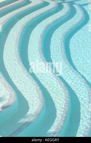 Contemporary patterned bold image of swimming pool steps seen above the water Stock Photo