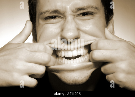 Expressions  male man young adult black and white b w making faces funny mouth teeth hands person expression emotion scary scari Stock Photo