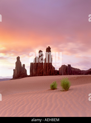 Sand dune and Totem Pole rock formation at sunrise Monument Valley Arizona Stock Photo