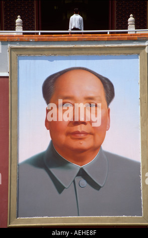 Man standing above giant portrait of Chairman Mao on Tiananmen Gate, Tiananmen Square, Beijing, China Stock Photo