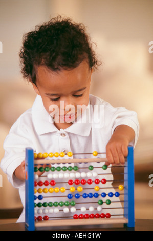 Boy months playing with abacus Stock Photo
