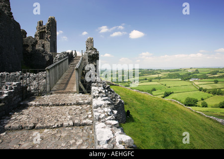 Ancient entrance to Welsh castle Carreg Cennen with dramatic views of a sunlit Welsh valley falling away to the right Wales GB Stock Photo