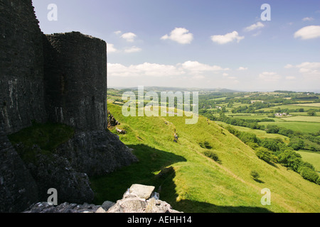 Side view of ancient Welsh castle Carreg Cennen with dramatic views of a sunlit Welsh valley falling away to the right Wales GB Stock Photo