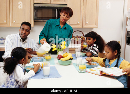 Family sitting together at breakfast table Stock Photo