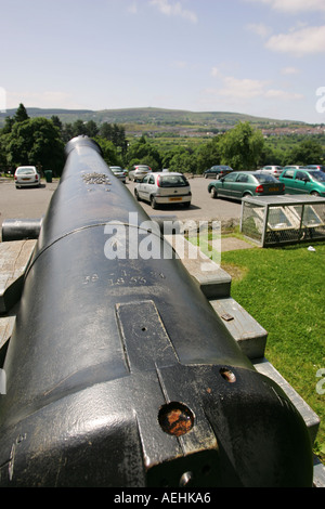 An acient iron canon stands in front of Cyfarthfa Castle Merthyr Tydfil overlooking the Brecon Beacons and Mid Glamorganshire Stock Photo