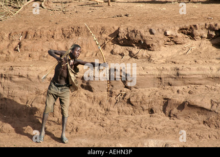 Hunter of hunter gatherer Hadza tribe hunting with bow and arrow near Lake Eyasi in Tanzania East Africa Stock Photo