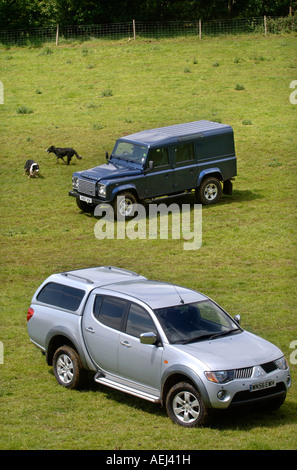 A LAND ROVER DEFENDER AND MITSUBISHI L200 PICK UP TRUCK ON A GLOUCESTERSHIRE SHEEP FARM UK Stock Photo