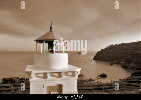 Trinidad Lighthouse with boats in harbor and sunset California Stock Photo