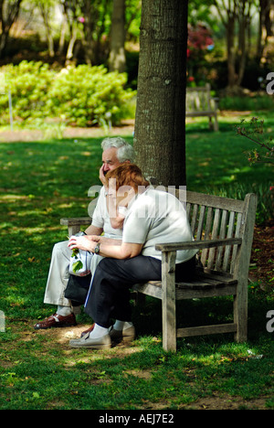 Couple of old people sitting on a bench and talking Stock Photo