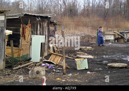 Woman in broken down poverty stricken yard Stock Photo
