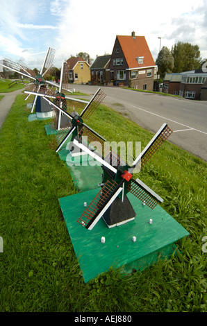 Row of small windmills by country road in Holland Stock Photo