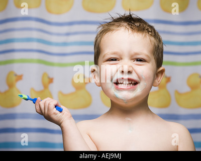 Boy with toothbrush in bathroom smiling Stock Photo