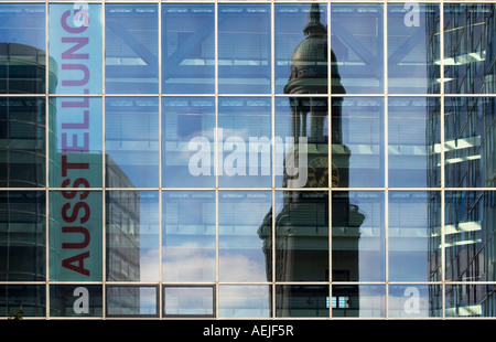 The tower of St. Michaelis Church reflected in the glass front of a modern office building, Hamburg, Germany
