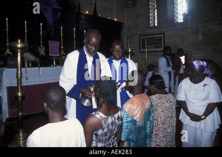 CHRISTIANITY priests distributing the holy sacraments during Communion Holy Trinity Church in Accra, Ghana Stock Photo