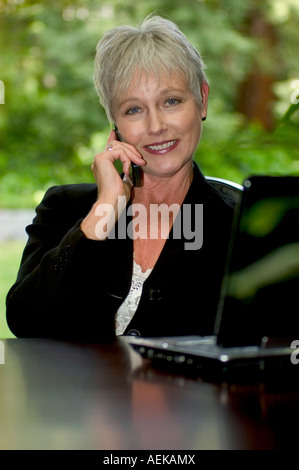 Mature woman in a business suit talking on a cell phone Stock Photo