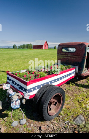 Old truck with flowers and barn Near flora Oregon Stock Photo