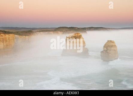 Two of the Twelve Apostles in mist at sunset near Port Campbell on the Great Ocean Road in Victoria Australia Stock Photo