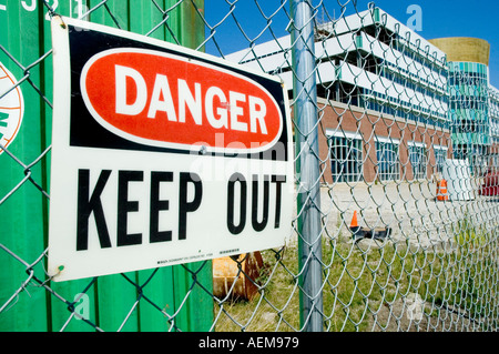 Sign on a cyclone fence stating danger keep out Stock Photo