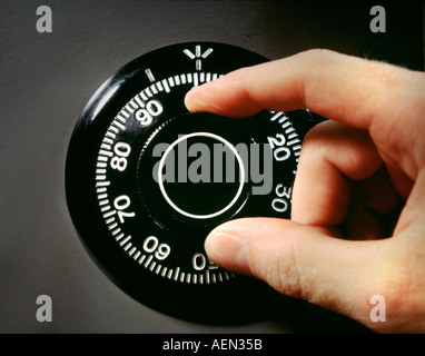 Hand turning a safe lock dial with numbers, punctuations, letters and ...